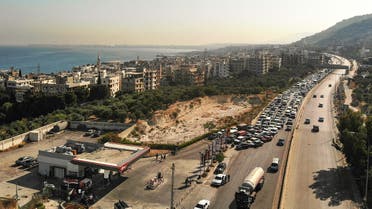 An aerial view show vehicles on the left lane adjacent to a petrol station queueing-up for fuel as traffic flows through on the Tripoli-Beirut highway at the coastal city of Qalamun in northern Lebanon on July 1, 2021 amidst severe fuel shortages.