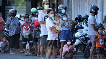 People wearing protective masks stand in line to receive a free meal amid a surge of coronavirus disease (COVID-19) cases in Bali, Indonesia July 28, 2021. (Reuters)