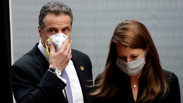 New York Governor Andrew Cuomo holds a protective mask to his face as he and Secretary to the Governor Melissa DeRosa arrive for a daily briefing at New York Medical College during the outbreak of the coronavirus disease (COVID-19) in Valhalla, New York, U.S., May 7, 2020. REUTERS/Mike Segar