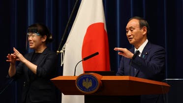Japan's Prime Minister Yoshihide Suga (R) attends a news conference on Japan's response to the coronavirus pandemic during the Tokyo 2020 Olympic Games in Tokyo, Japan. (AP)