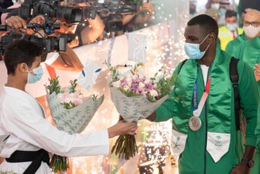 Saudi Arabian Olympic champion and Karate player Tarek Hamedi accepts a bouquet of flowers from an aspiring karate player. (Twitter)