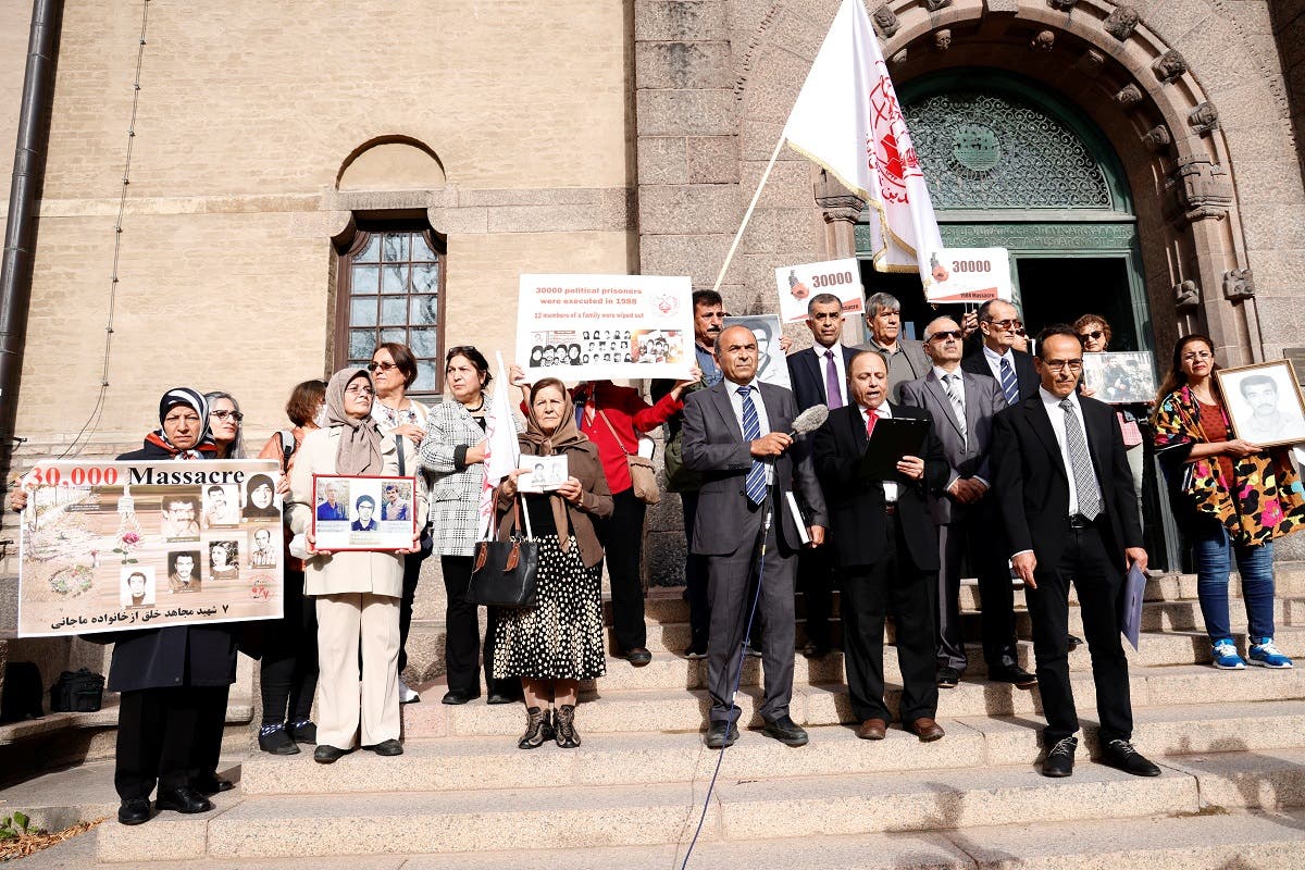 Supporters of People’s Mojahedin Organization of Iran protest outside Stockholm District Court on the first day of the trial of Hamid Noury, 60, accused of involvement in the massacre of political prisoners in Iran in 1988, Stockholm, Sweden, on August 10, 2021. (Reuters)