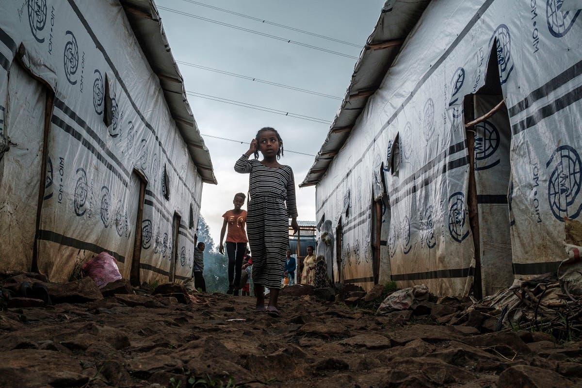 Internally displaced children run in an alley of a camp in the town of Azezo, Ethiopia, on July 12, 2021. (Eduardo Soteras/AFP)