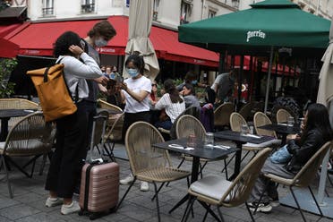 A waitress checks clients’ health passes at a restaurant in Paris, August 9, 2021. (AP/Adrienne Surprenant)