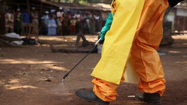 A member of the French Red Cross disinfects the area around a motionless person suspected of carrying the Ebola virus as a crowd gathers in Forecariah, Guinea, January 30, 2015. (File Photo: Reuters)