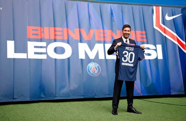 Lionel Messi after signing for Paris St Germain poses with a shirt on the pitch after the press conference, Paris, France, August 11, 2021. (Reuters)