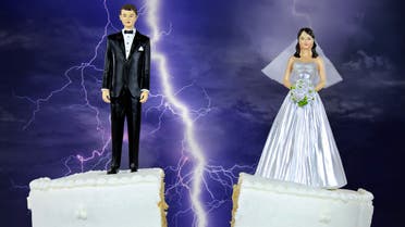Bride and groom on split wedding cake stock photo