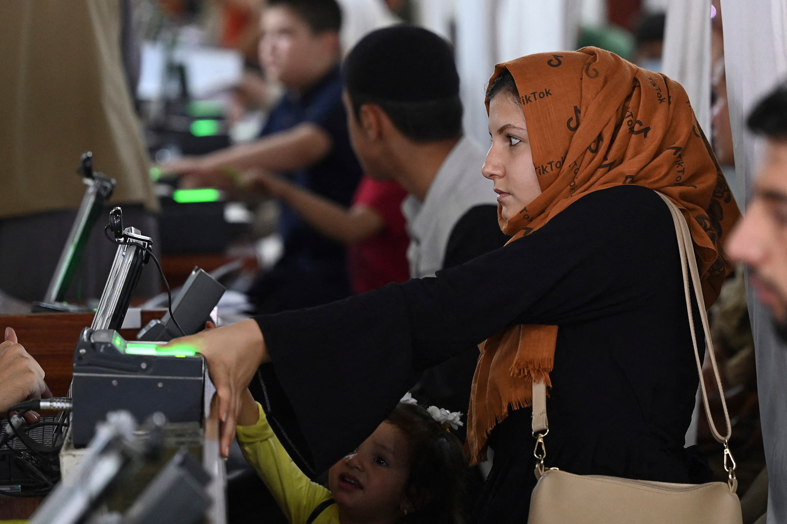 An Afghan woman gives her fingerprints for a passport amid Taliban advance in the country