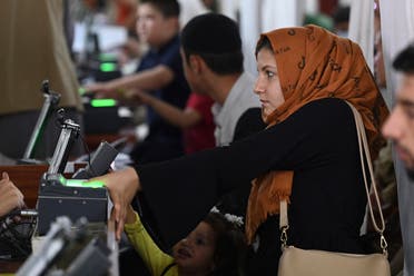 سيدة أفغانية تعطي بصماتها للحصول على جواز سفر وسط تقدم طالبان في البلاد