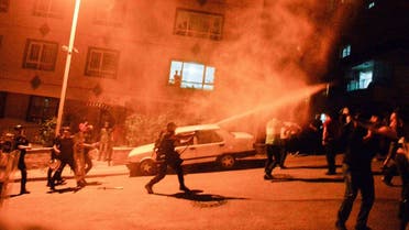Turkish police use tear gas to disperse men who smash up shops and homes, believed to be owned by Syrian families, during an unrest, which broke out in response to a fight between locals and migrants in which one Turkish national was stabbed to death, in Ankara, on August 12, 2021, overnight. (AFP)