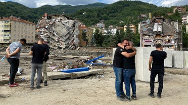 Locals react as they stand near partially collapsed buildings as the area was hit by flash floods that swept through towns in the Turkish Black Sea region, in the town of Bozkurt, in Kastamonu province, Turkey, August 14, 2021. (Reuters/Bulent Usta)