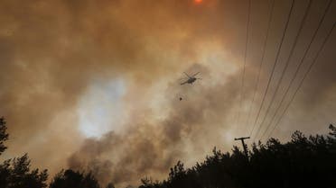 A firefighting helicopter returns from extinguishing a forest fire near Marmaris, Turkey, July 30, 2021. (Reuters/Kenan Gurbuz)