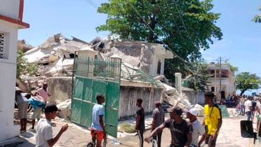 People stand outside the residence of the Catholic bishop after it was damaged by an earthquake in Les Cayes, Haiti, August 14, 2021. (AP/Delot Jean)