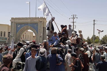 Taliban fighters stand on a vehicle along the roadside in Kandahar on August 13, 2021. (AFP)