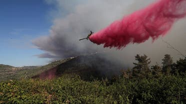 A firefighting plane disperses fire retardant as it assists in extinguishing a fire near the Israeli village of Shoresh at the outskirts of Jerusalem August 15, 2021. (Reuters/Ronen Zvulun)