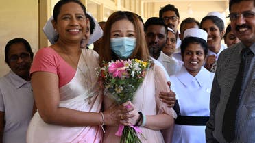 A Chinese tourist (C), who was tested positive for the COVID-19 coronavirus and isolated for treatment, poses for photographs with Sri Lankan Health Minister Pavithra Wanniarachchi (front L) and medical staff after she was discharged from the main infectious diseases hospital near Colombo on February 19, 2020, following her recovery. (File photo: AFP)