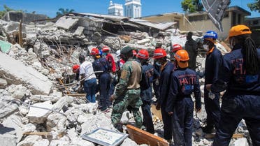 Members of a rescue and protection team clean debris from a house after a 7.2 magnitude earthquake in Les Cayes, Haiti August 15, 2021. (Reuters/Ralph Tedy Erol)