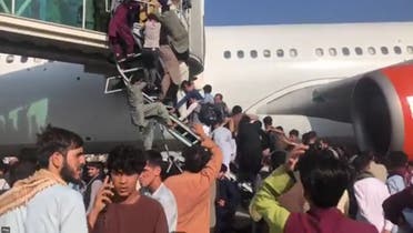 Screengrab from a video showing Afghans attempting to climp aboard an aircraft at Kabul airport. (Twitter)
