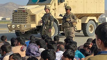 Afghans crowd at the airport as US soldiers stand guard in Kabul on August 16, 2021. (AFP)