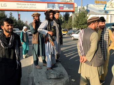 عناصر من طالبان خارج مطار حامد كرزاي الدولي في كابل (رويترز)