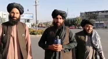 A man, who purportedly is a Taliban militant, holds a wireless microphone as he speaks on the street in Kabul, Afghanistan. (A still image taken from social media video uploaded August 16, 2021 and obtained by Reuters) .