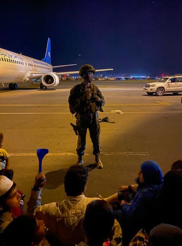 جندي أميركي يؤمن إقلاع الرحلات وسط الفوضى في مطار كابل ليلة الاثنين الثلاثاء