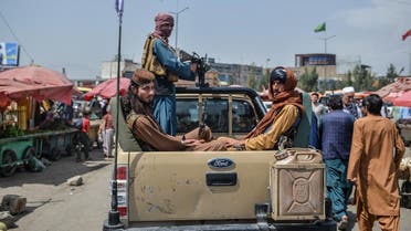 Taliban fighters on a pick-up truck move around a market area, flocked with local Afghan people at the Kote Sangi area of Kabul on August 17, 2021. (Hoshang Hashimi/AFP)
