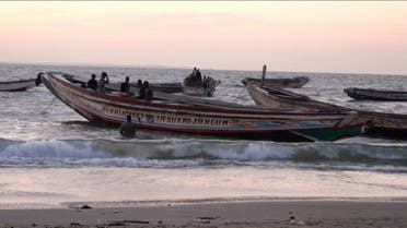 This image grab taken from an AFP video shows boats in the water at a beach, in Barra on December 5, 2019, after at least 62 people died on December 4, 2019 when their makeshift vessel capsized off the coast of Mauritania, including 52 migrants from Gambia. (Romain Chanson/AFPTV/AFP)