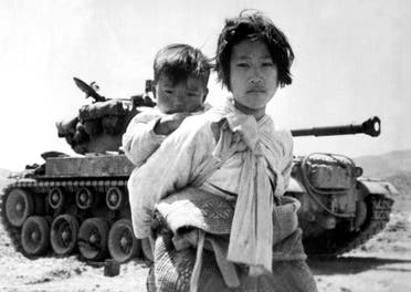 لاجئة من كوريا الجنوبية وهي تحمل شقيقها على ظهرها مع بداية الغزو الشمالي