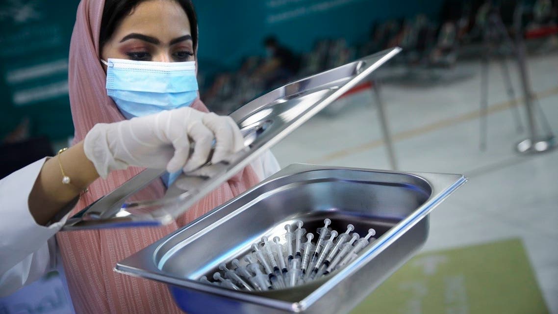 A Saudi health worker carries a tray of Pfizer coronavirus vaccines, at a vaccination center in the old Jeddah airport, Saudi Arabia, Tuesday, May 18, 2021. (AP)