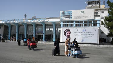 Afghan passengers carry their belongings as they come out from the domestic terminal, at the Kabul airport in Kabul on August 8, 2021.