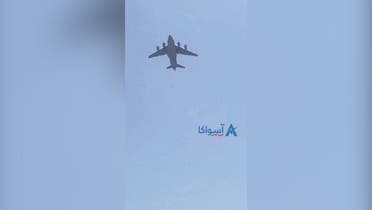 A U.S. Air Force plane flies overhead after social media videos showed people clinging to the plane on the tarmac at Kabul airport on August 16, 2021. (ASVAKA NEWS/via Reuters)