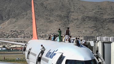 Afghan people climb atop a plane as they wait at the Kabul airport in Kabul on August 16, 2021, after a stunningly swift end to Afghanistan's 20-year war, as thousands of people mobbed the city's airport trying to flee the group's feared hardline brand of Islamist rule. (File photo: AFP)