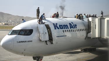 Afghan people climb atop a plane as they wait at the Kabul airport in Kabul on August 16, 2021. (File photo: AFP)
