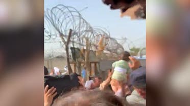 Screengrab from a video showing an Afghan trying to hand a baby to soldiers at Kabul airport. (Twitter)