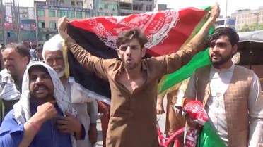 People carry Afghan flags as they take part in an anti-Taliban protest in Jalalabad, Afghanistan August 18, 2021 in this screen grab taken from a video. (Reuters) 