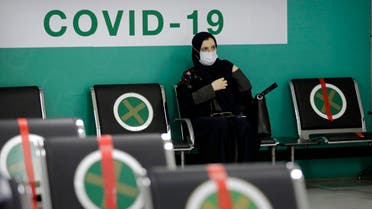 A woman waits to receive her first dose of the Pfizer coronavirus vaccine at a vaccination center, at the old Jiddah airport, Saudi Arabia, Tuesday, May 18, 2021. (AP)