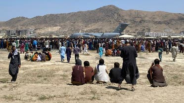 Hundreds of people gather near a US Air Force C-17 transport plane at the perimeter of the international airport in Kabul, Afghanistan, Monday, Aug. 16, 2021. (AFP)