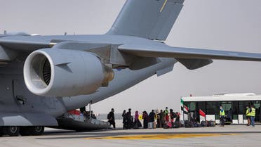 People disembark off a Royal Air Force military aircraft carrying evacuees from Afghanistan and arriving at Al-Maktoum International Airport on August 19, 2021. (AFP)