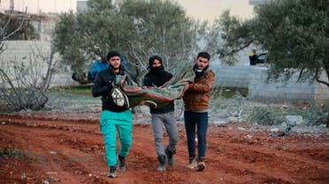Syrian men carry a child's body after airstrikes destroyed his family house at the northern town of Sarmin, in Idlib province, Syria, on Feb. 2, 2020. (AP)