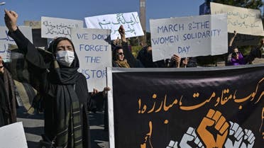 Women demonstrators hold banners as they march toward to the governor office during a peaceful protest to mark International Women's Day in Herat on March 8, 2021. (AFP)