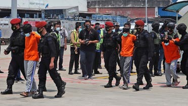 Police escort suspected militants upon arrival at the Soekarno-Hatta International Airport in Tangerang, Indonesia, March 18, 2021. (AP)