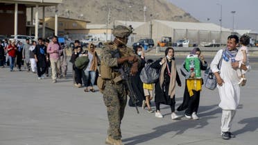 جندي أميركي وعائلات أفغانية تستعد للإجلاء من مطار كابل بعد سيطرة طالبان - فرانس برس