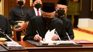 In this photo released by Malaysia’s Department of Information, Malaysia's new Prime Minister Ismail Sabri Yaakob, signs documents after taking the oath as the country’s new leader at the National Palace in Kuala Lumpur. (AP)