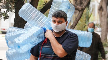 A man covers his face with a makeshift mask as he carries empty gallons of water, during a lockdown to prevent the spread of coronavirus disease (COVID-19) in Beirut, Lebanon April 6, 2020. (Reuters)