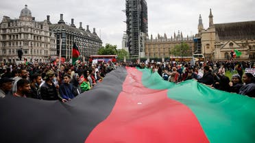 Protesters display a giant Afghan flag as they demonstrate in solidarity with the people of Afghanistan, in Parliament Square, central London on August 21, 2021. (Tolga Akmen/AFP)