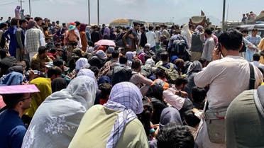 Afghan people gather along a road as they wait to board a US military aircraft to leave the country, at a military airport in Kabul on August 20, 2021 days after Taliban’s military takeover of Afghanistan. (Wakil Kohsar/AFP)