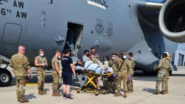 Medical support personnel from the 86th Medical Group help an Afghan mother and family off a US Air Force C-17 moments after she delivered a child aboard the aircraft upon landing at Ramstein Air Base, Germany. (Twitter)