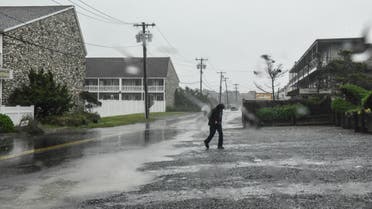 MONTAUK, NY - AUGUST 22: A person walks across the street on August 22, 2021 in Montauk, New York. Tropical Storm Henri was downgraded from a Category 1 Hurricane on Sunday morning as heavy rain pounded the east end of Long Island. Stephanie Keith/Getty Images/AFP