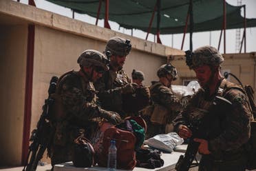 Marines with the 24th Marine Expeditionary Unit (MEU) search luggage during an evacuation at Hamid Karzai International Airport, Kabul, Afghanistan, in this photo taken on August 18, 2021 and released by U.S. Navy on August 20, 2021. (Reuters)